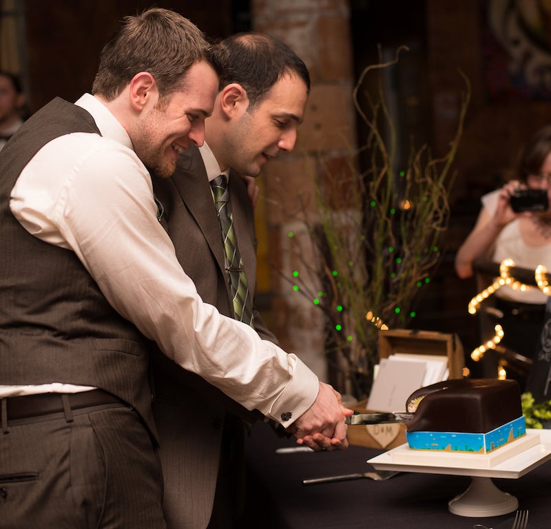 Razavi and his husband cutting their wedding cake