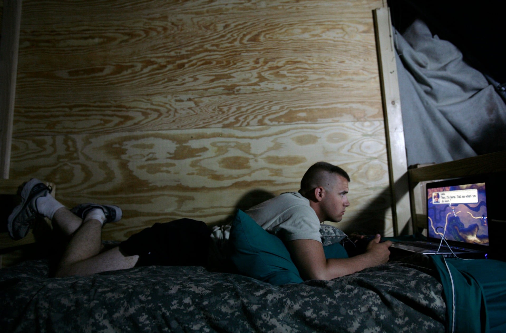 A U.S. soldier playing a video game in his barracks in Iraq (2009)