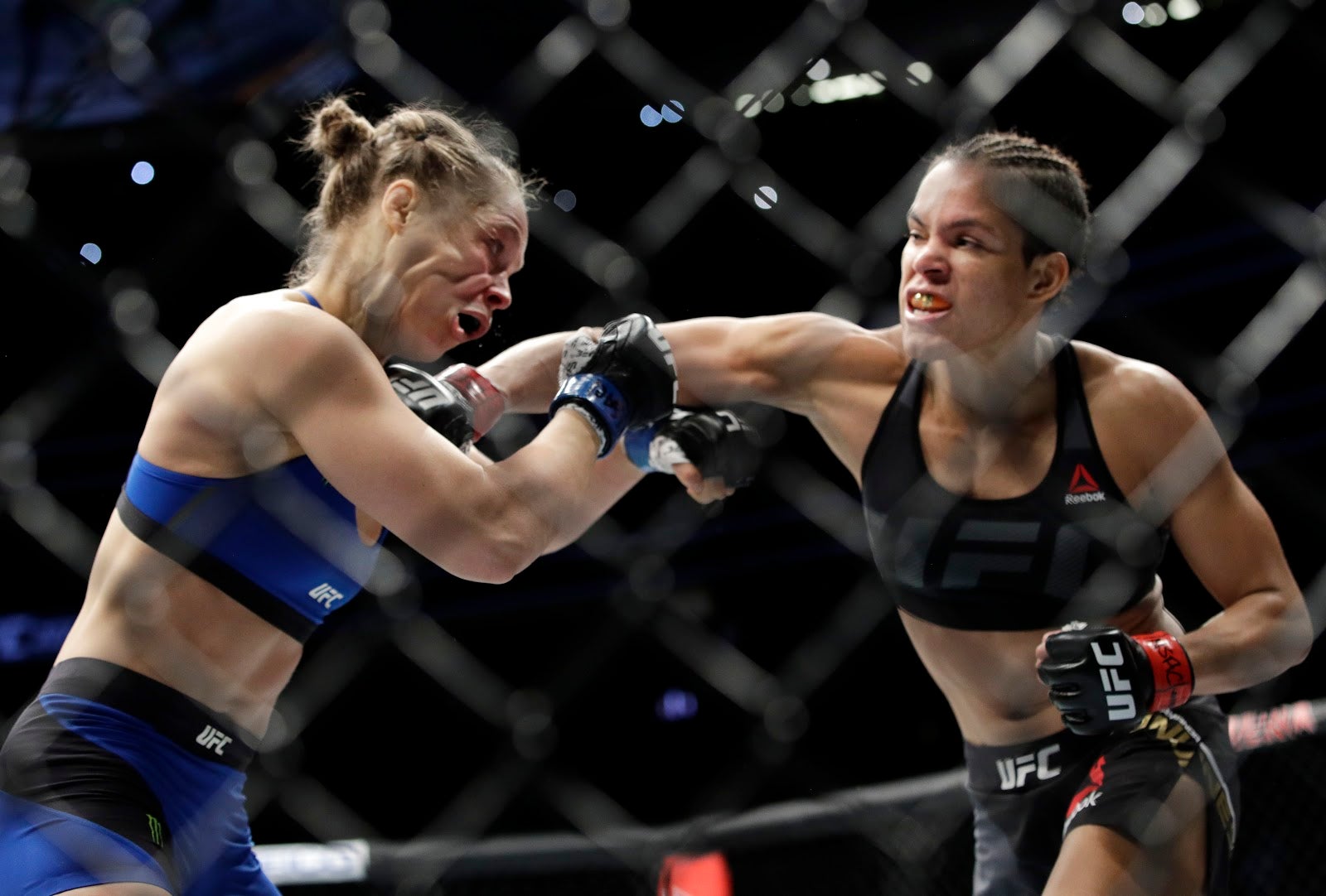 Amanda Nunes, right, connects with Ronda Rousey in the first round of their women’s bantamweight championship mixed martial arts bout at UFC 207, in Las Vegas. 