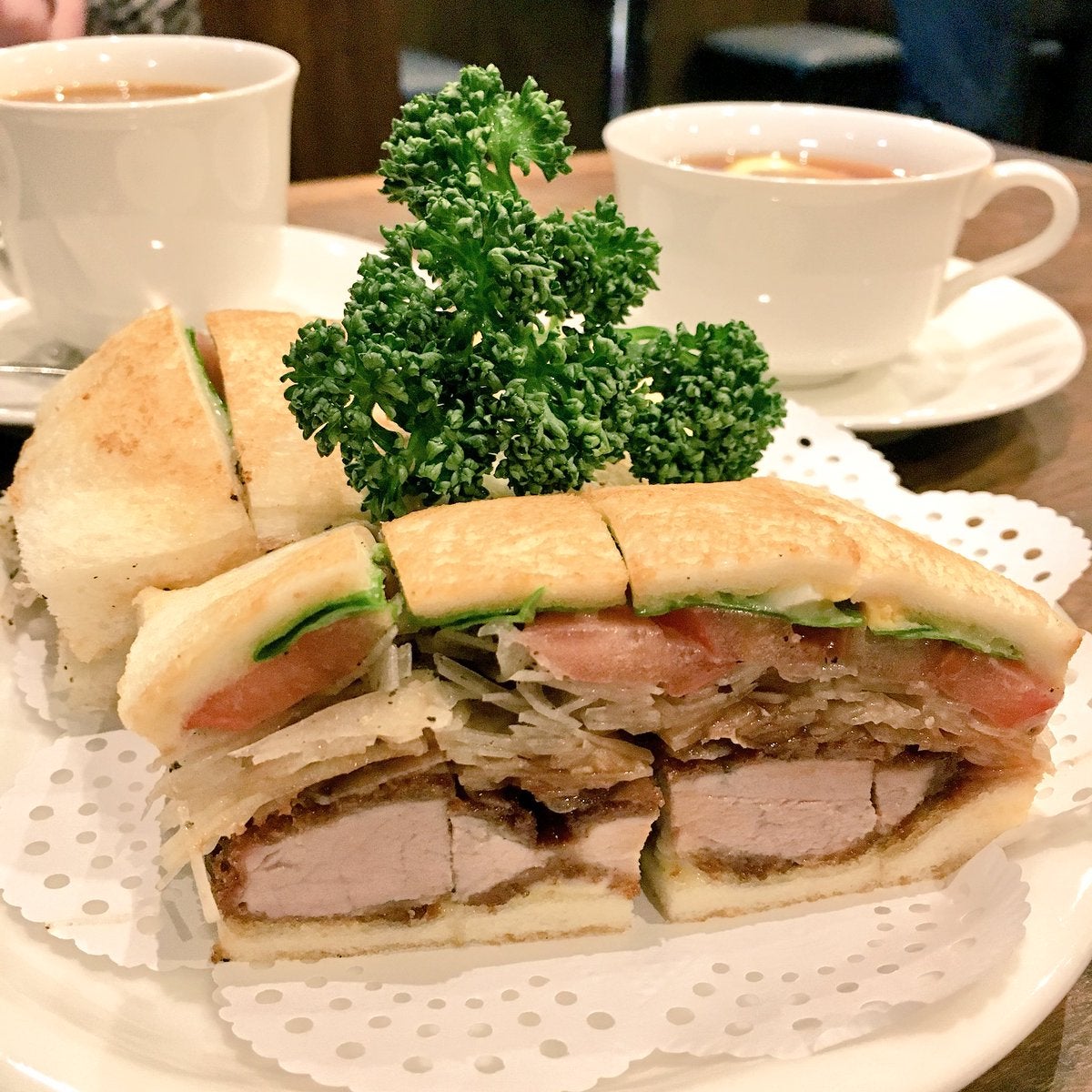 Katsu sando with sliced onions, tomato and lettuce. Note how the sando comes cut into bite-sized portions.