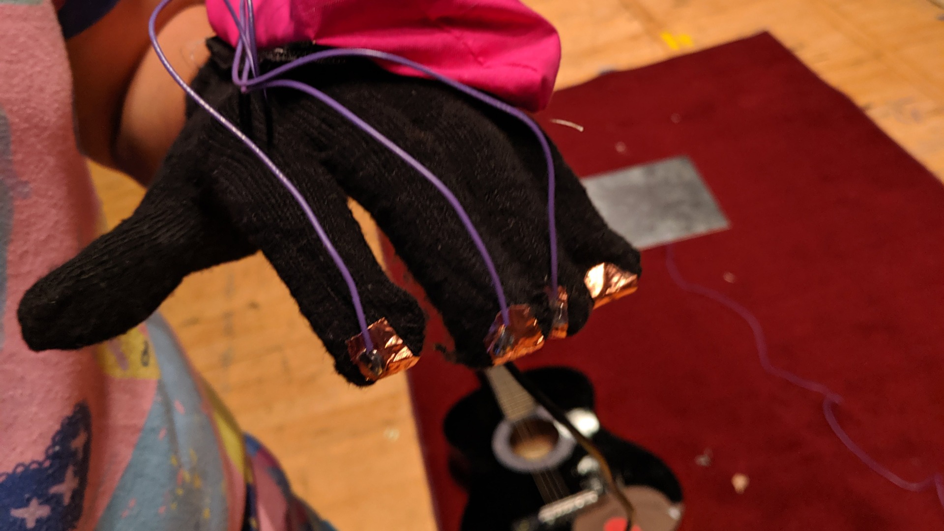 The custom glove controller that read players’ finger inputs. In the background can be seen the metal plate onto which the guitars were smashed.