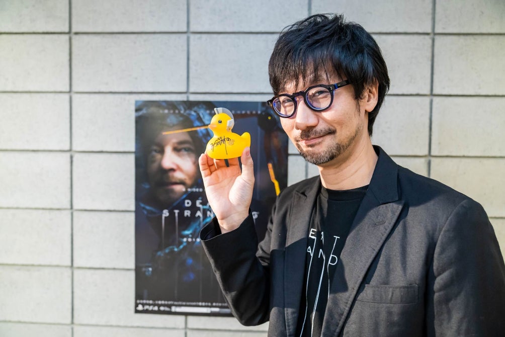 Kojima holds up a rubber ducky.
