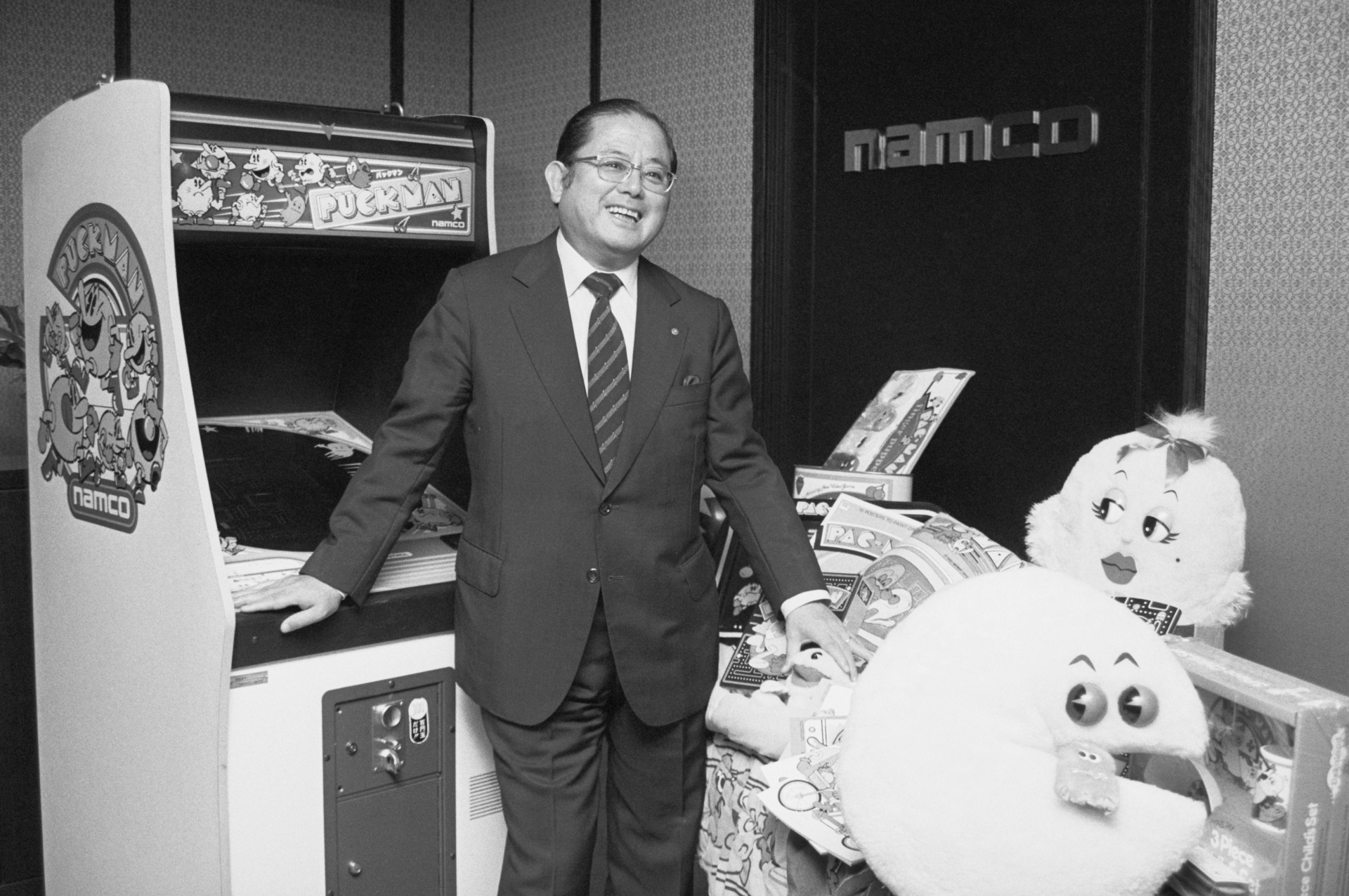 Namco founder Masaya Nakamura poses next to a Puck-Man machine at the company’s Tokyo office on November 6, 1982.