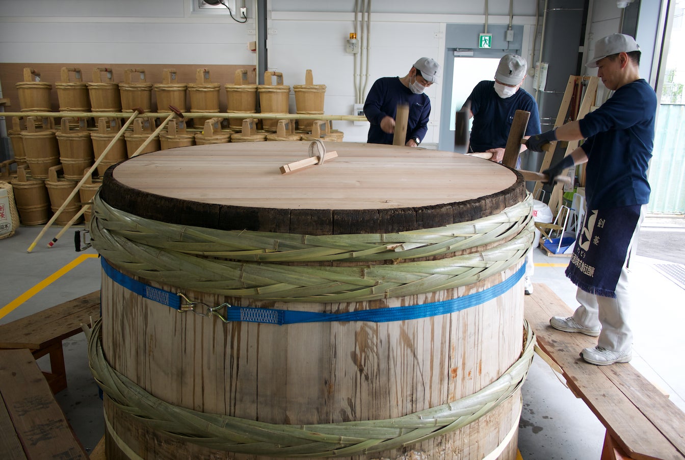 Coopers fix a wooden tub at Kenbishi in Kobe’s Nada brewing district. 