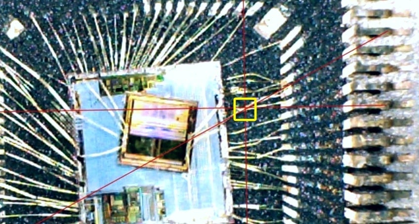 Pictured is inside the MediaTek chip package. The yellow box shows where the two lines intersect. Hackers aimed to drill exactly at this point.