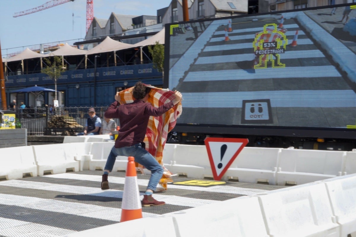 A player holds a blanket to obscure their silhouette and fool the AI.