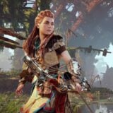 Aloy holds her bow in the wilderness.