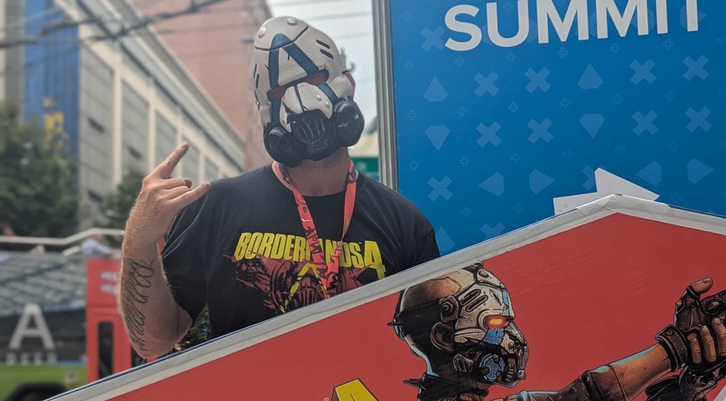 A man stands with a Borderlands 4 sign at PAX West.