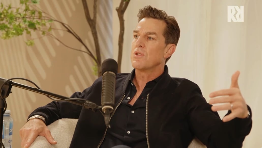 Andrew Wilson talks on a podcast.