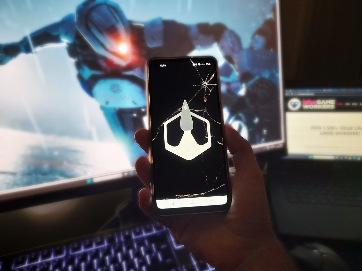 A phone shows the BARB logo in front of a computer.