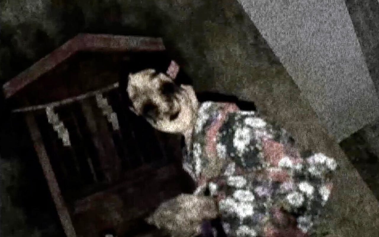 A woman with blacked-out eyes turns to face the camera.