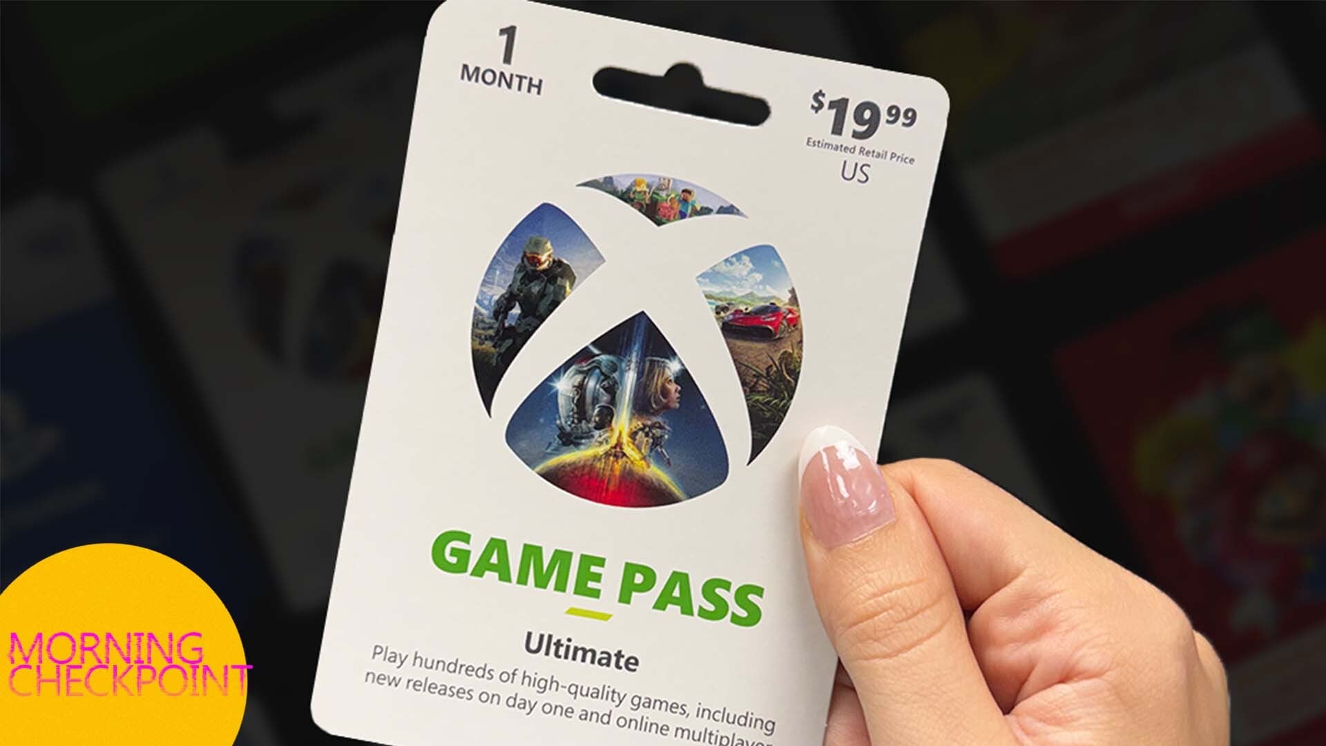 A hand holds a Game Pass card.