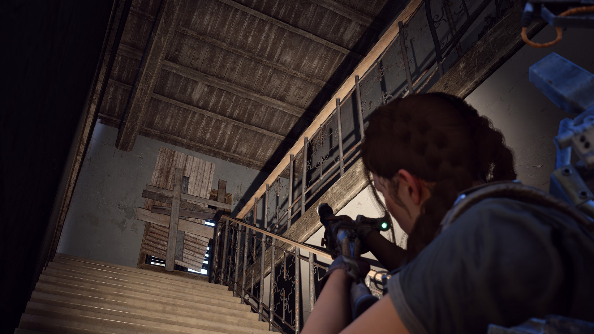 A player character walks up the stairs in an abandoned house.