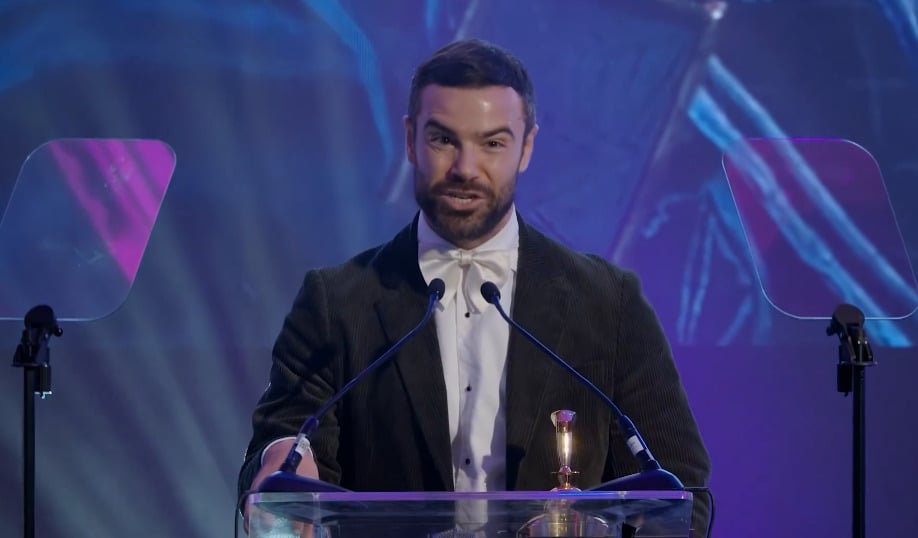 Ben Starr stands at a podium giving a speech