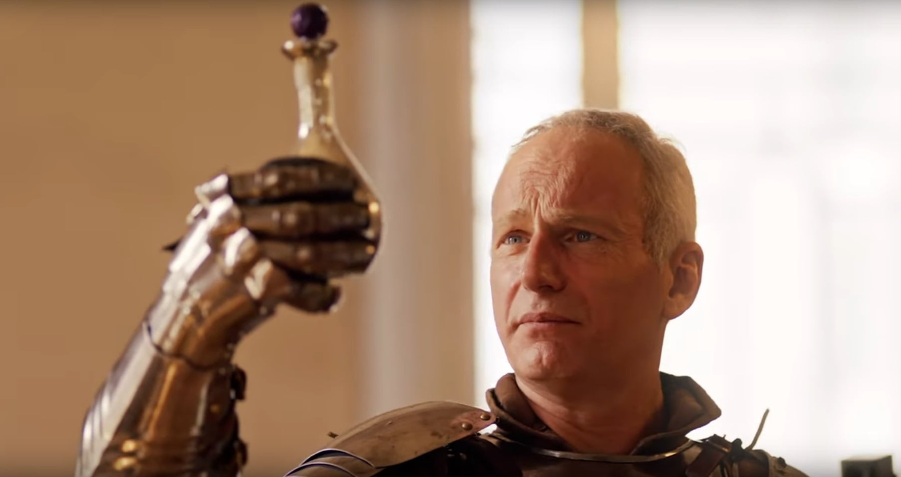 A man holds up a vial of strange liquid.