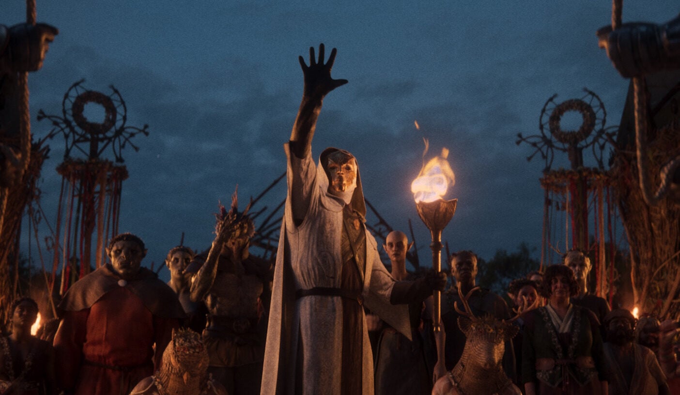 A man holds up his hand during a ritual.