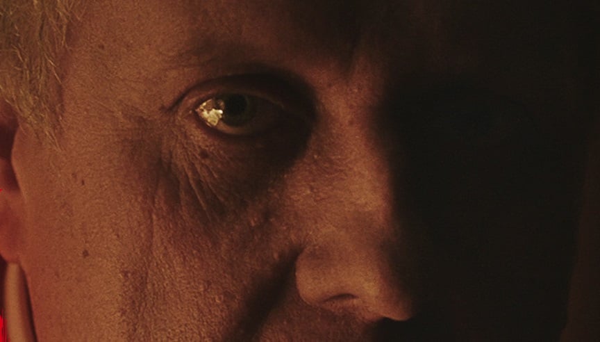 A man's eye appears in the dark.