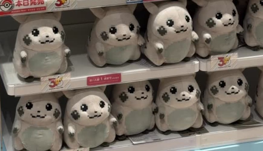 Pikachu Plushies sit on a shelf.